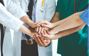チーム医療を象徴する医療スタッフが手を重ねるイメージ